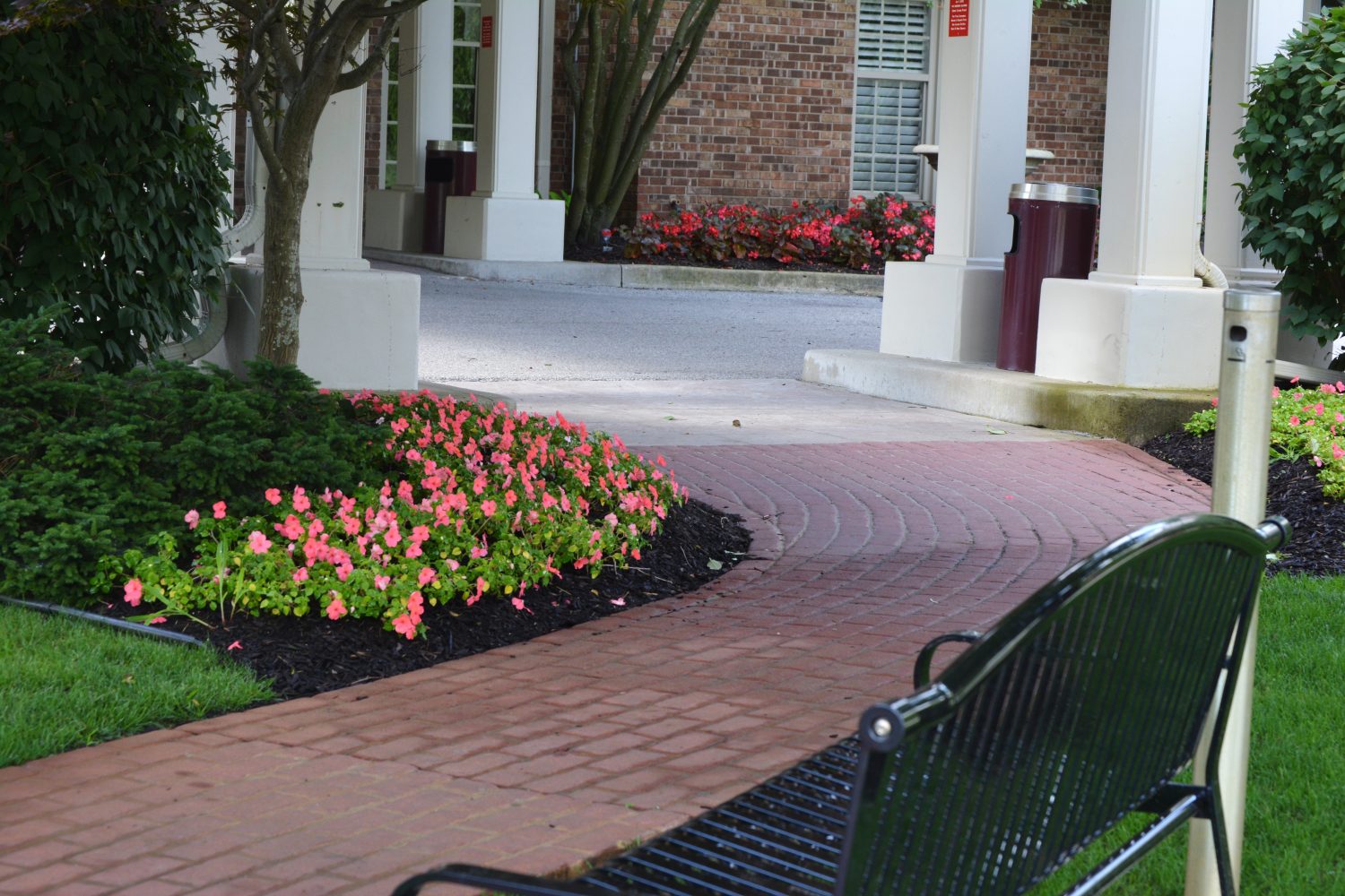 Mulched flower beds lining a brick path